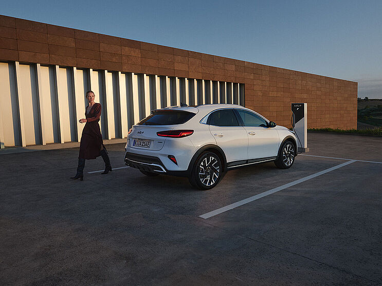 Kia XCeed Weiss Heckansicht Parkierter Kia XCeed weiss mit Person
